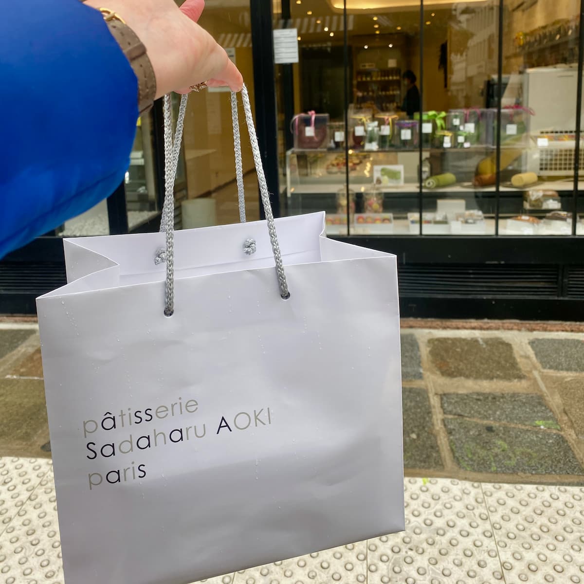 shiny white patisserie bag in front of a Paris shop