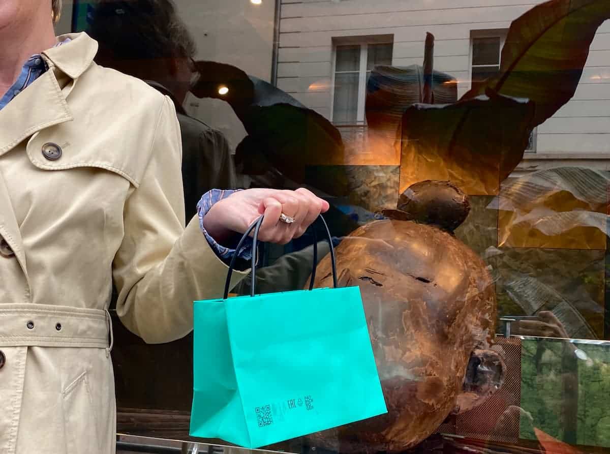 holding a turquoise famous French chocolate bag in Paris