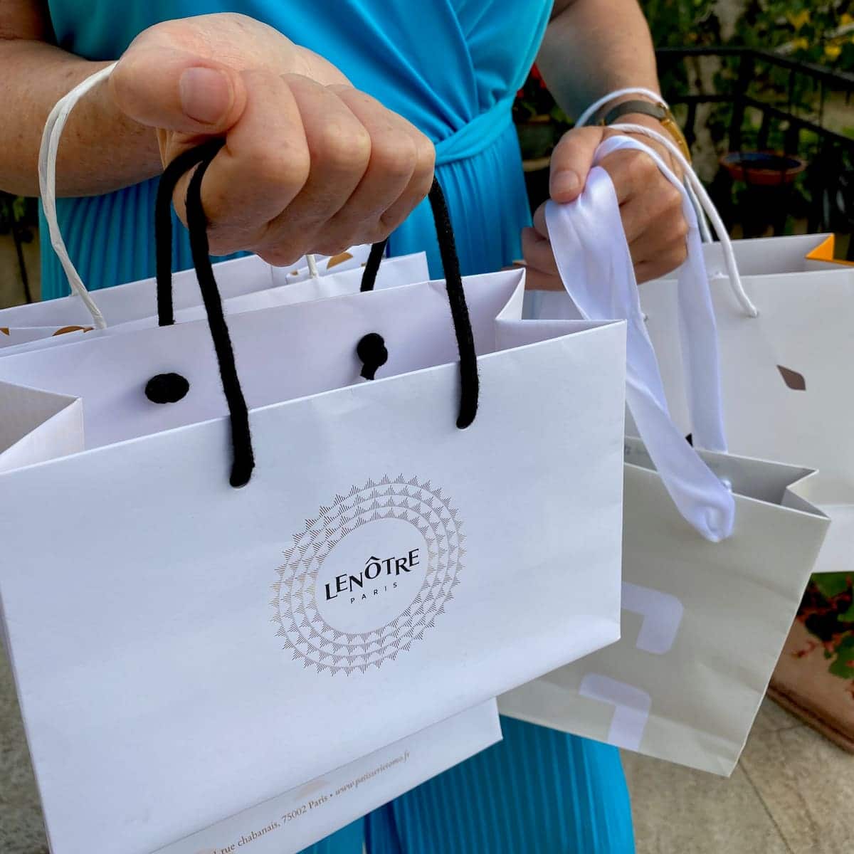 carrying many white and cream Patisserie bags to recycle