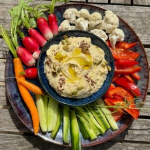 bowl of creamy chickpea spread with extra garlic the French way, served with raw vegetables