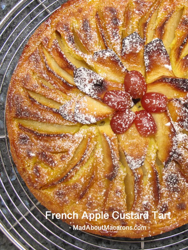 large apple tart with custard filling and topped with grapes for decoration