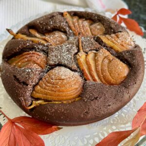 round chocolate cake topped with sliced golden pears