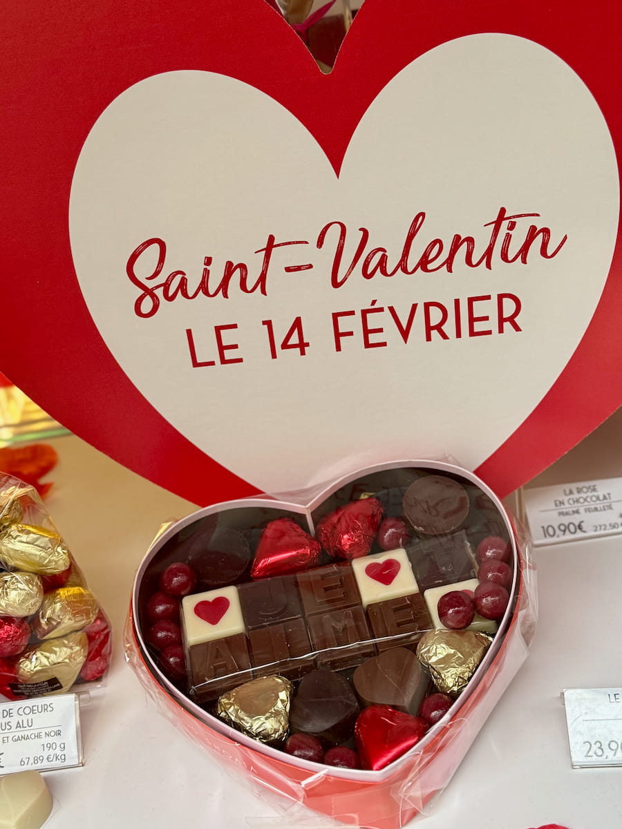 large heart with a chocolate box saying 'Je t'aime' in French in a Parisian shop window saying Saint-Valentin le 14 février