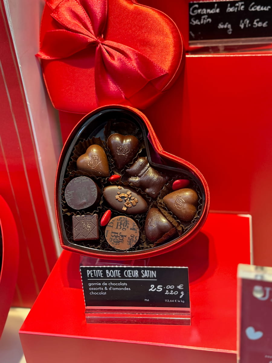 heart shaped box filled with heart shaped chocolates for Valentine's Day in a Parisian window