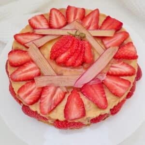 rhubarb and custard cheesecake, decorated with rhubarb chips and strawberries