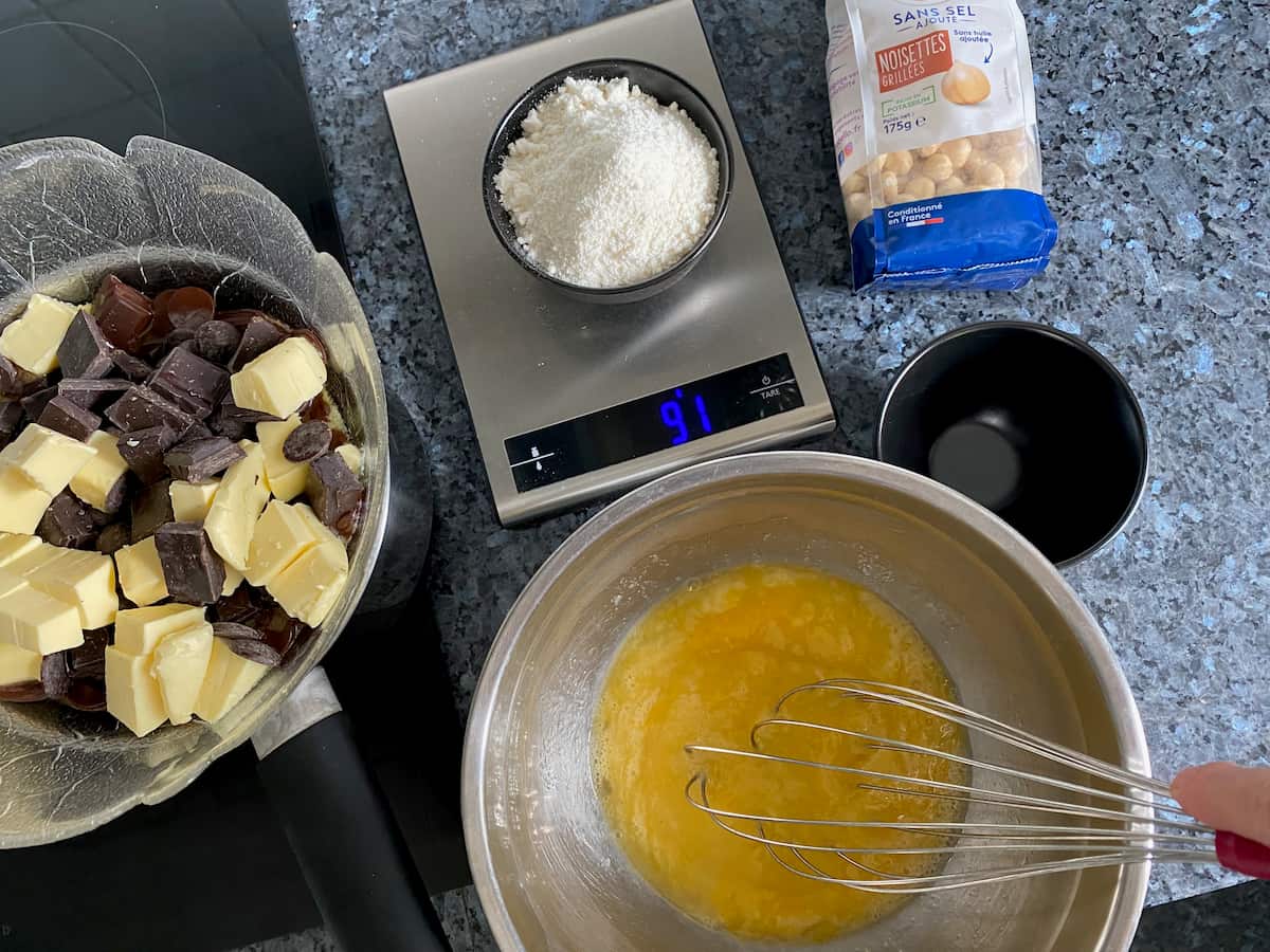 whisking eggs and sugar while chocolate and butter melting in a double boiler, weighing out rice flour
