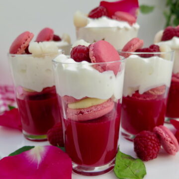 mini shot glasses with dark rose jelly, pink macarons and topped with cream and raspberries