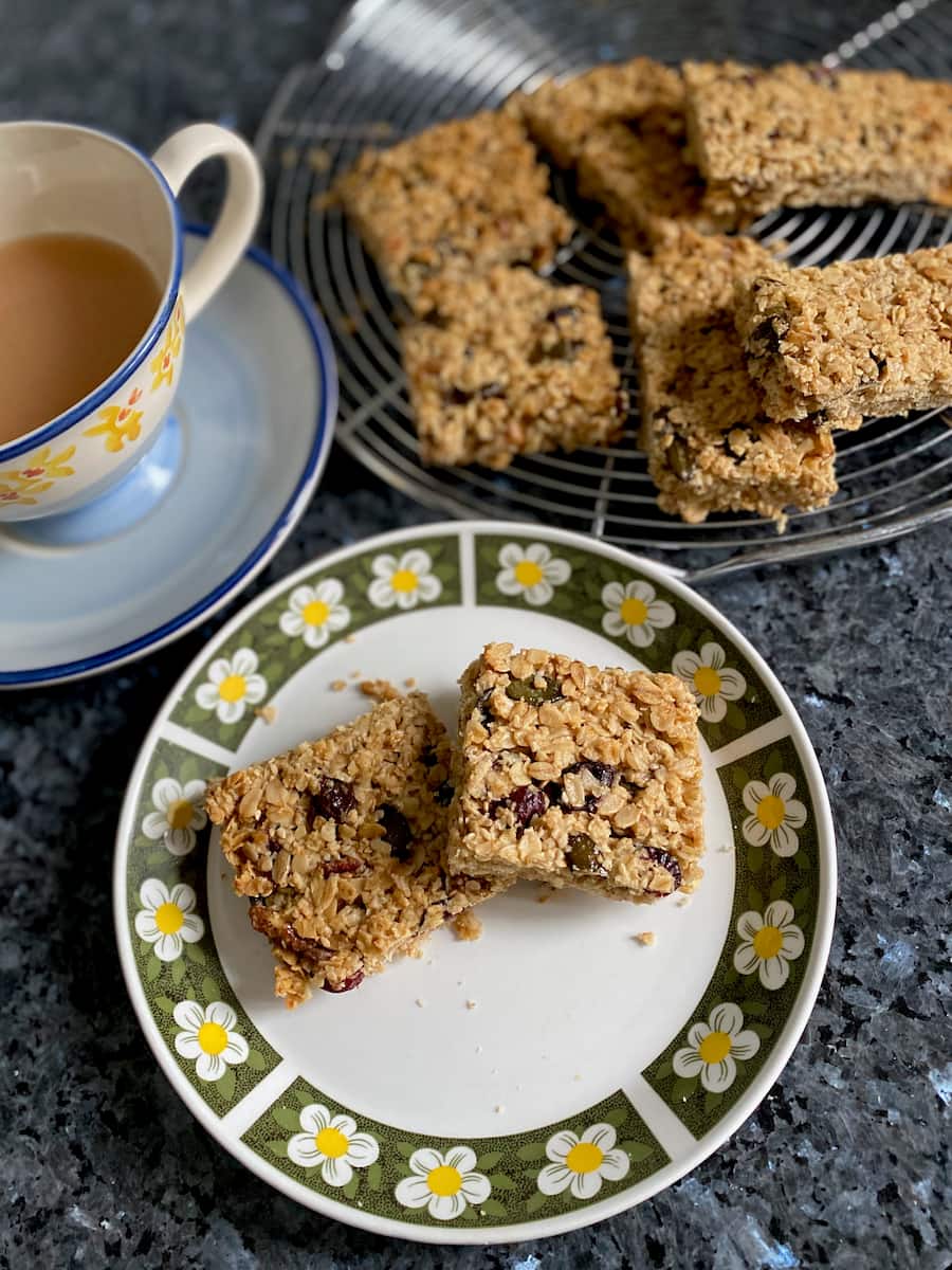 fruit and nut flapjack granola squares on plate with a cup of tea