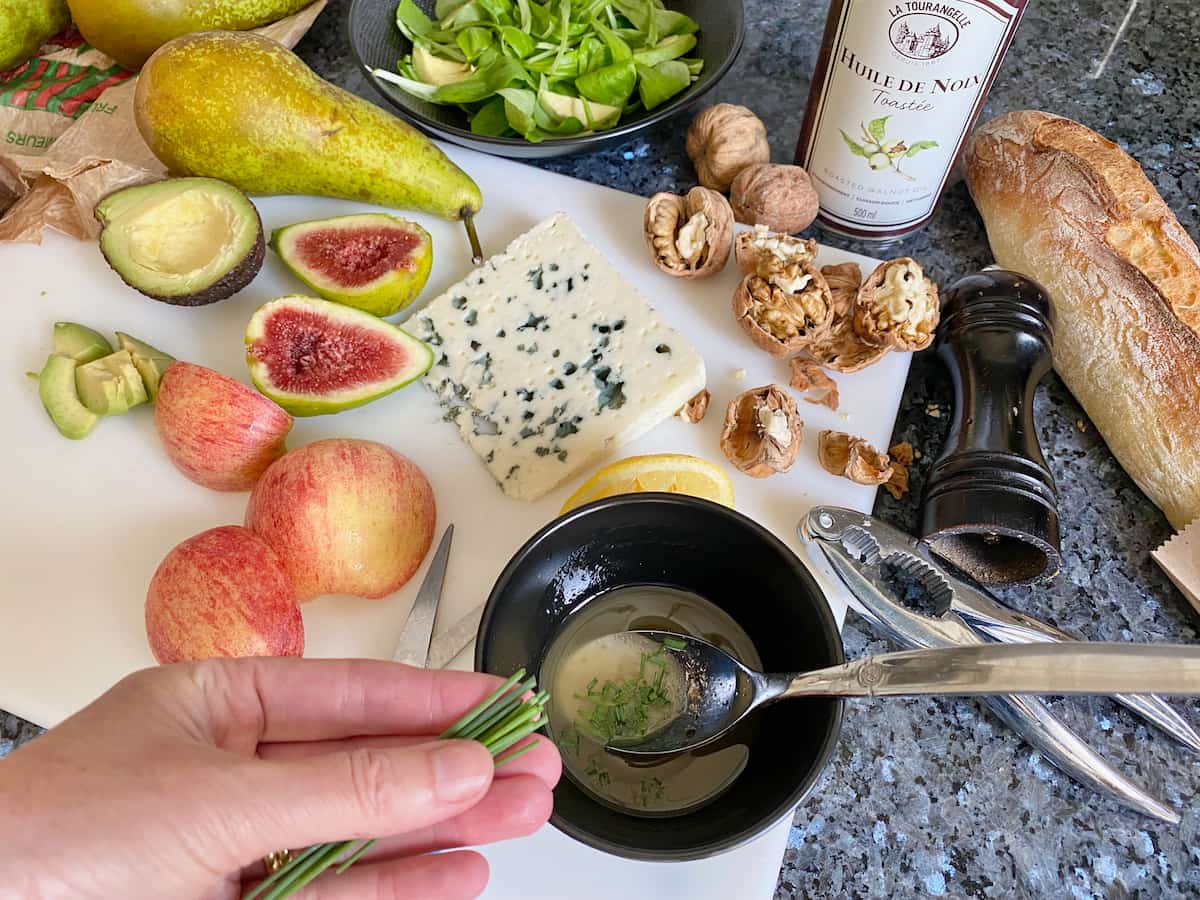 preparing a Roquefort salad dressing with fresh chives and vinaigrette