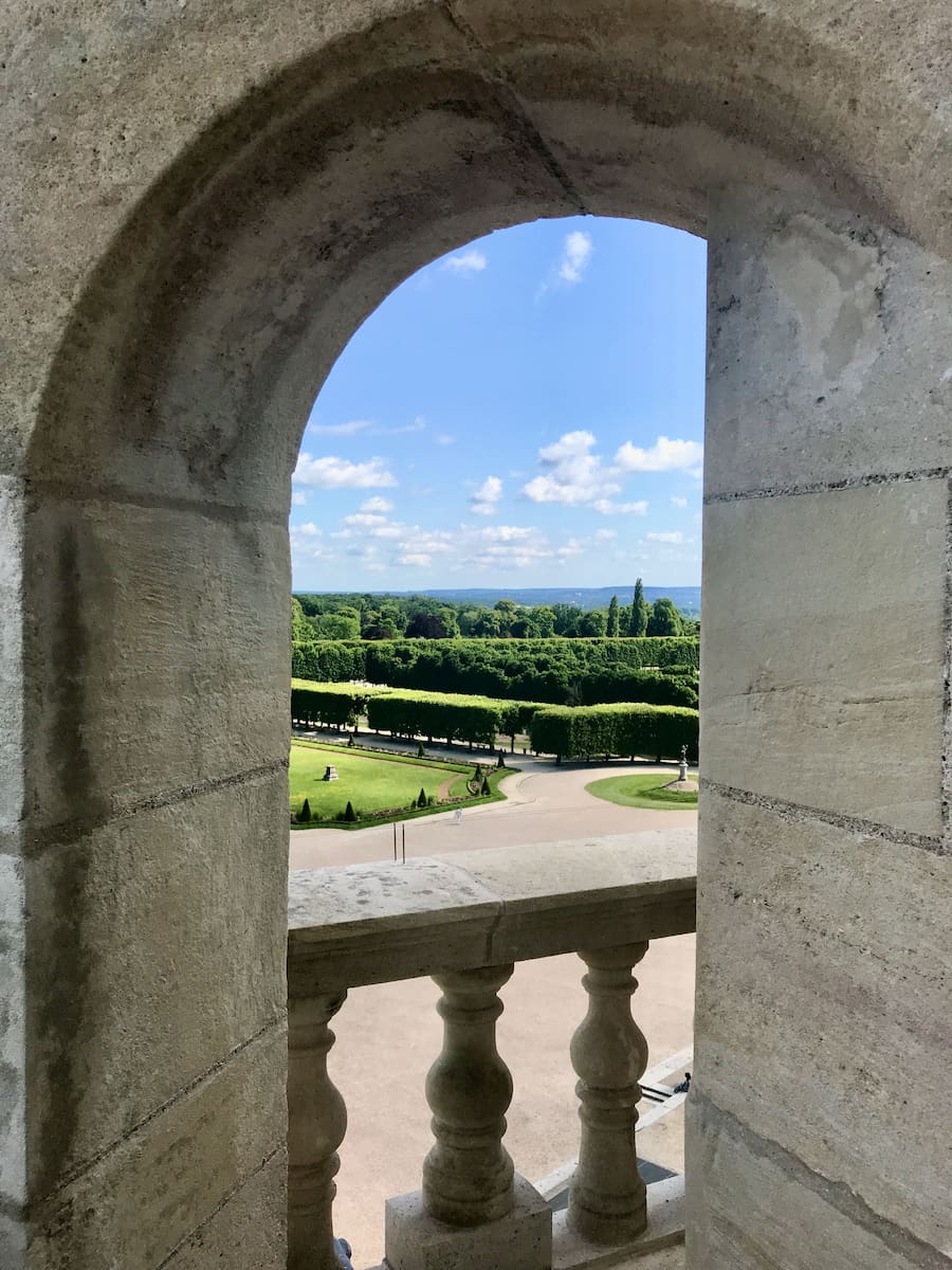 archway on a castle roof, with a glimpse of a French royal garden