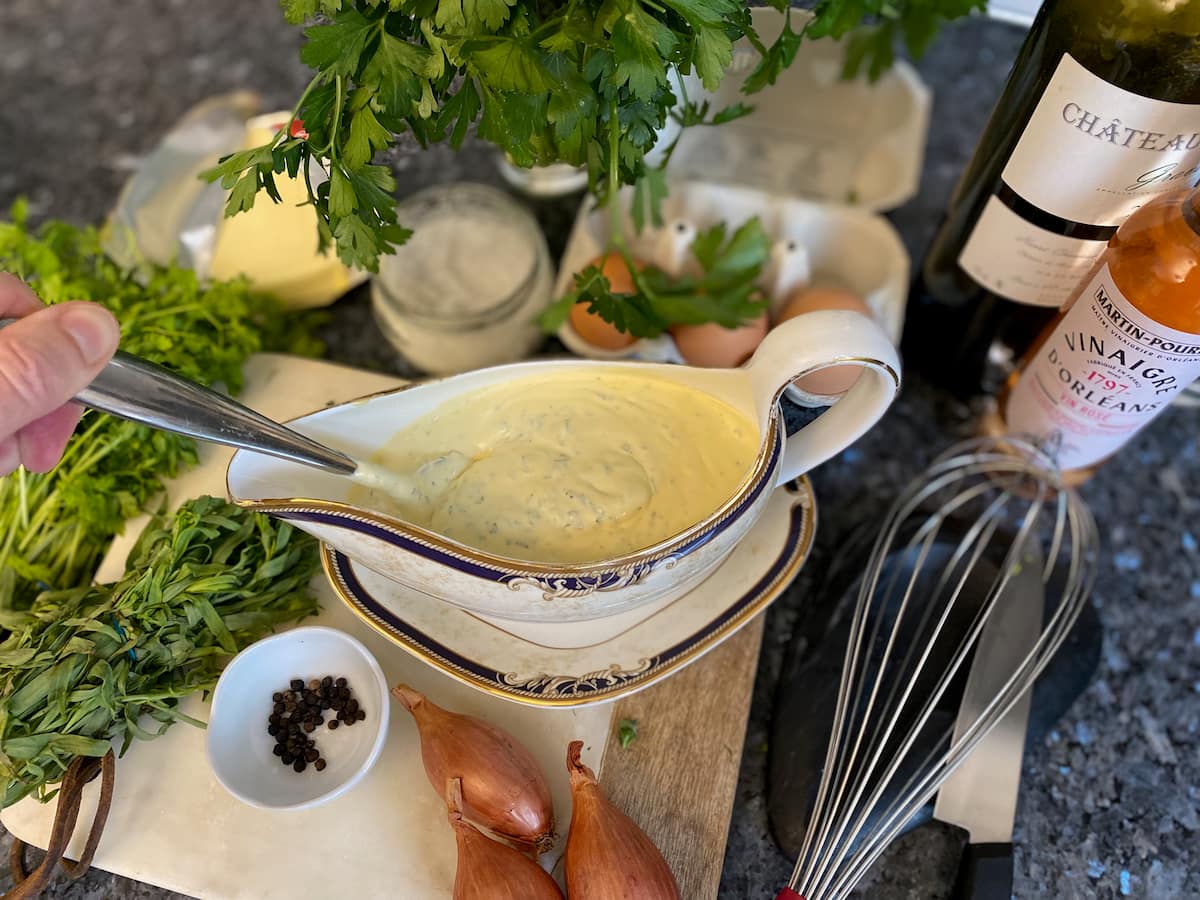 sauce serving dish filled with a creamy yellow herb sauce surrounded by its ingredients