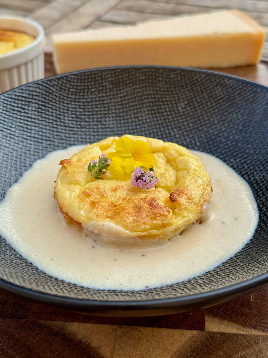 white baked asparagus recipe served in a pool of creamy parmesan sauce