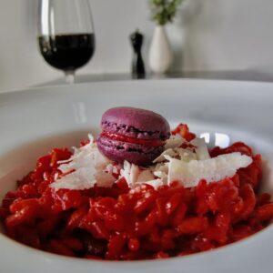 purple beet risotto with purple macaron and glass red wine