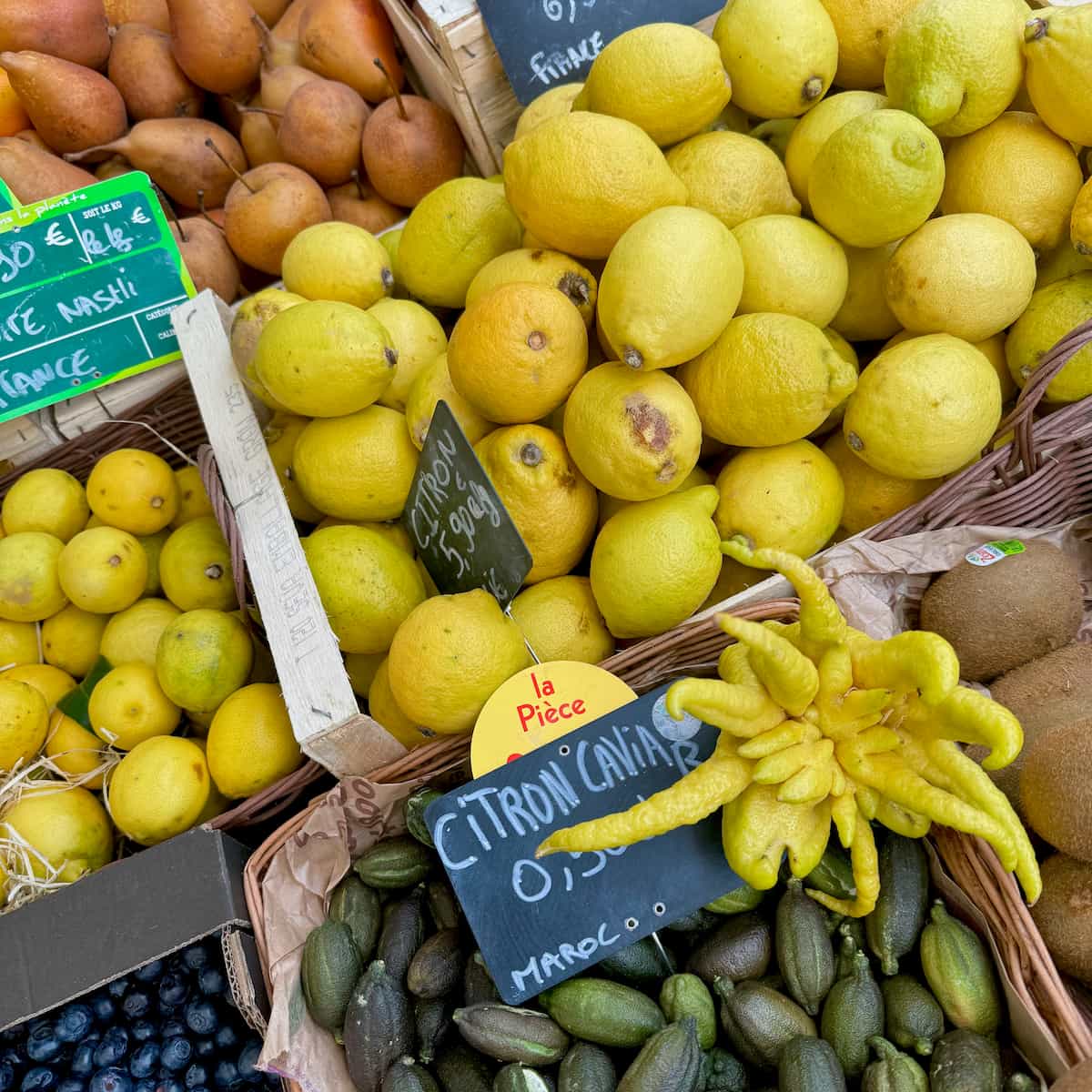 baskets of different fresh lemon varieties in a French market