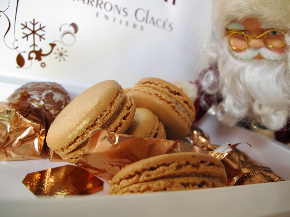 Santa Claus looking at candied chestnut macarons in a box