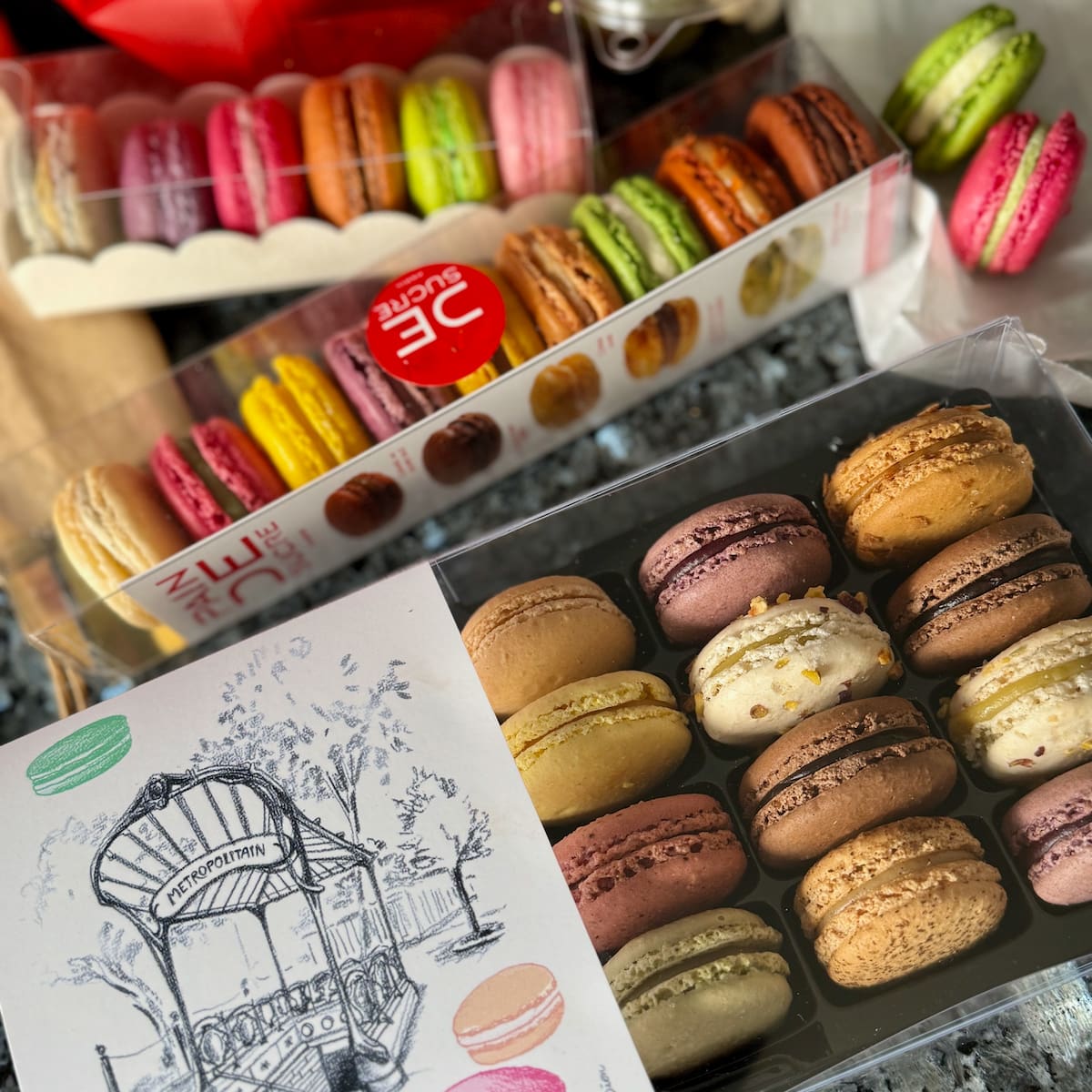 boxes of various different French macarons from Paris to taste for the ultimate guide