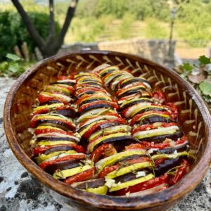 French baking dish of sliced roasted summer vegetables