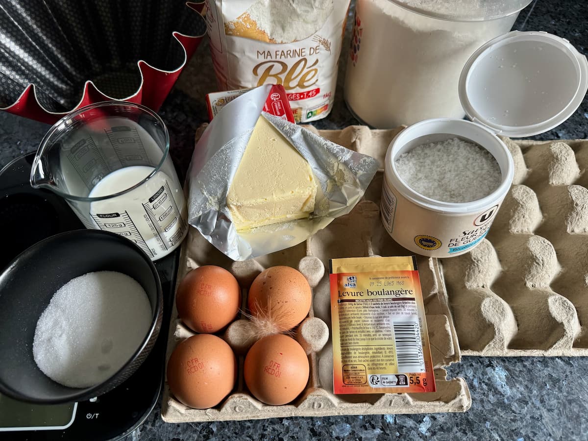 ingredients laid out to make a French brioche: flour, eggs, butter, sugar, yeast and salt