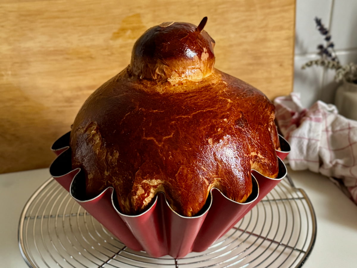 large shiny Parisian brioche in a fluted tin and little head on top