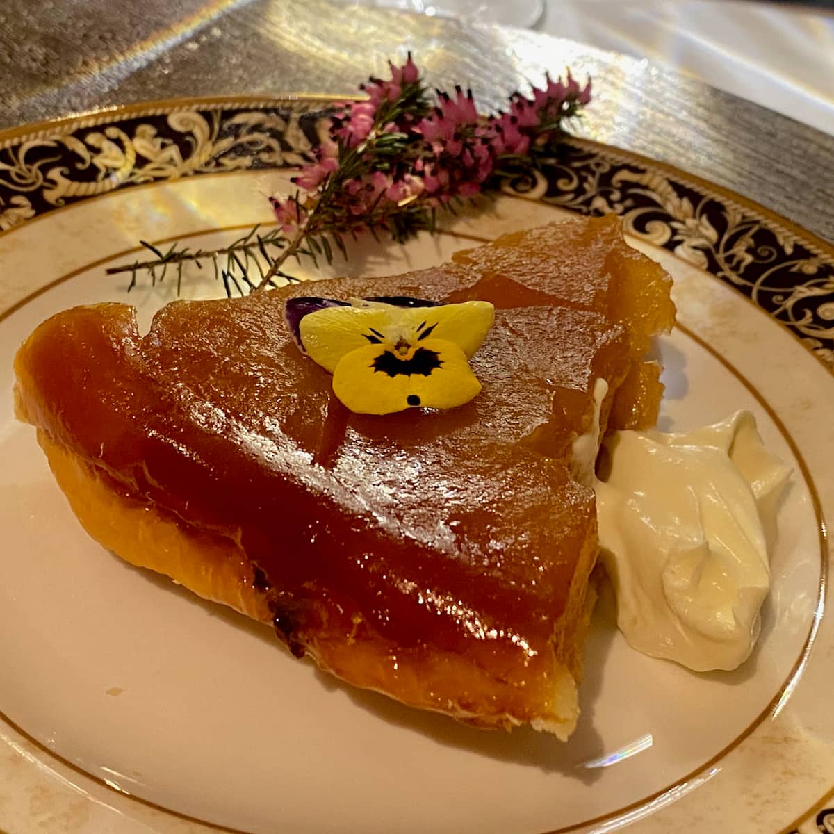 slice of caramelised apple tarte tatin on plate with a dollop of creme fraiche