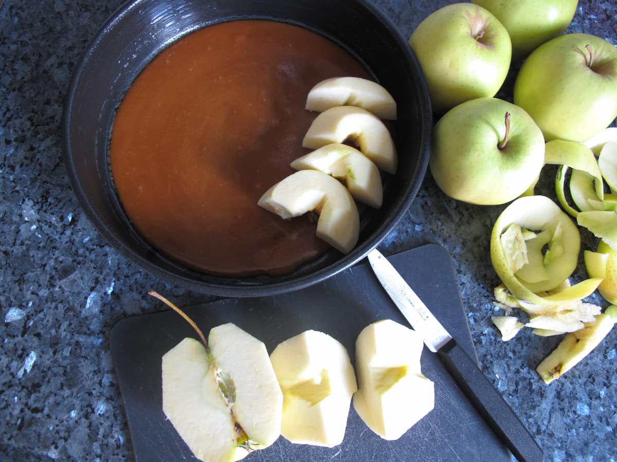 layering apples in a pan of caramel
