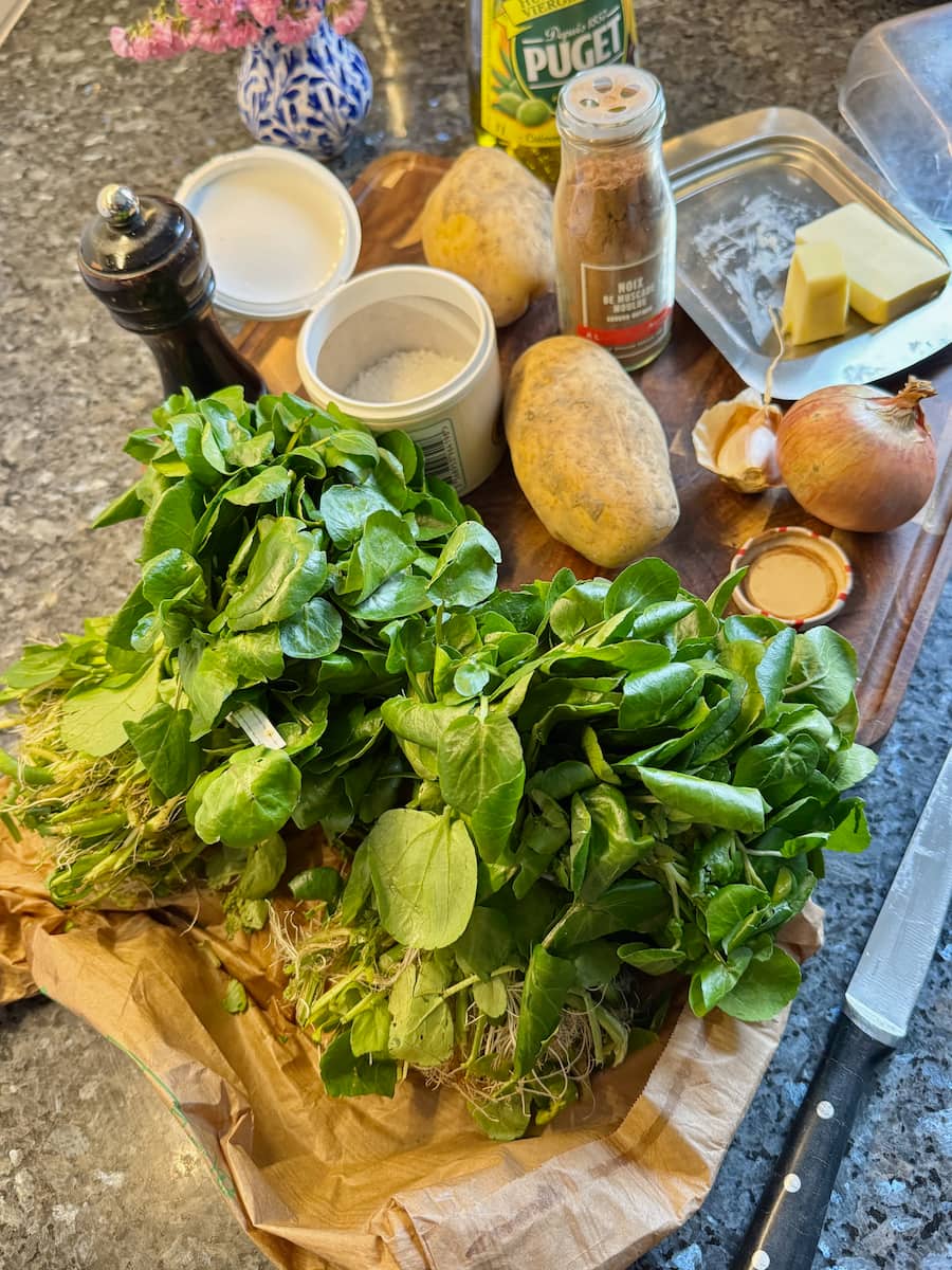 bundles of fresh watercress, potatoes, an onion, garlic, nutmeg, butter, olive oil, salt and pepper to make watercress soup