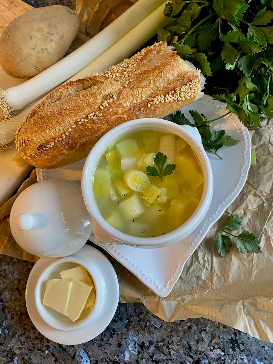bowl of soup with leeks, potatoes, French baguette and butter