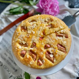 moist cake showing roasted rhubarb and toasted almonds on top