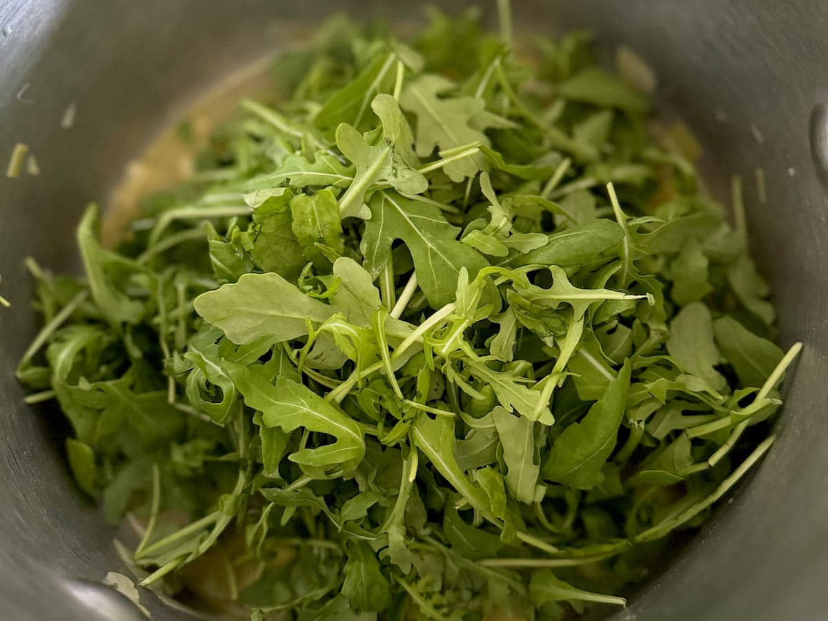 pile of fresh rocket leaves (arugula) in a soup pot