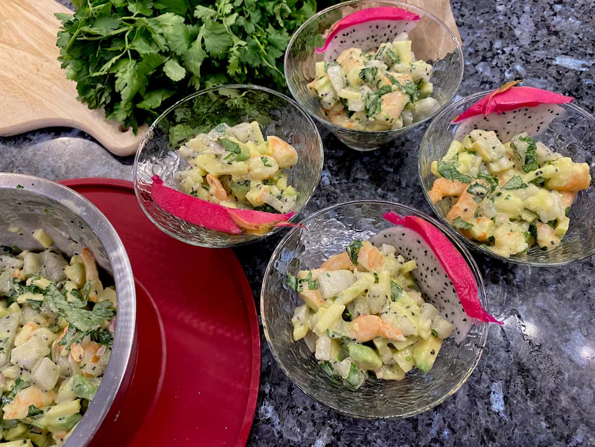 cocktail glass dishes with prawns, dragon fruit, avocado and coriander leaves 