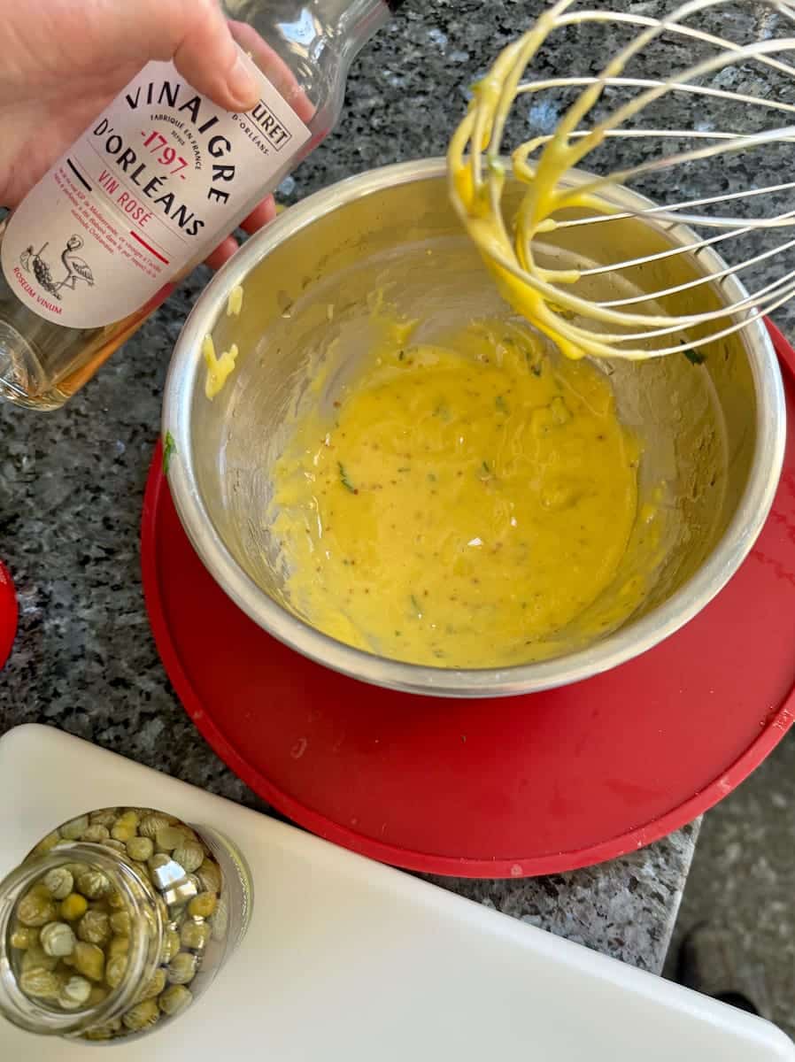 whisking homemade mayonnaise, adding vinegar
