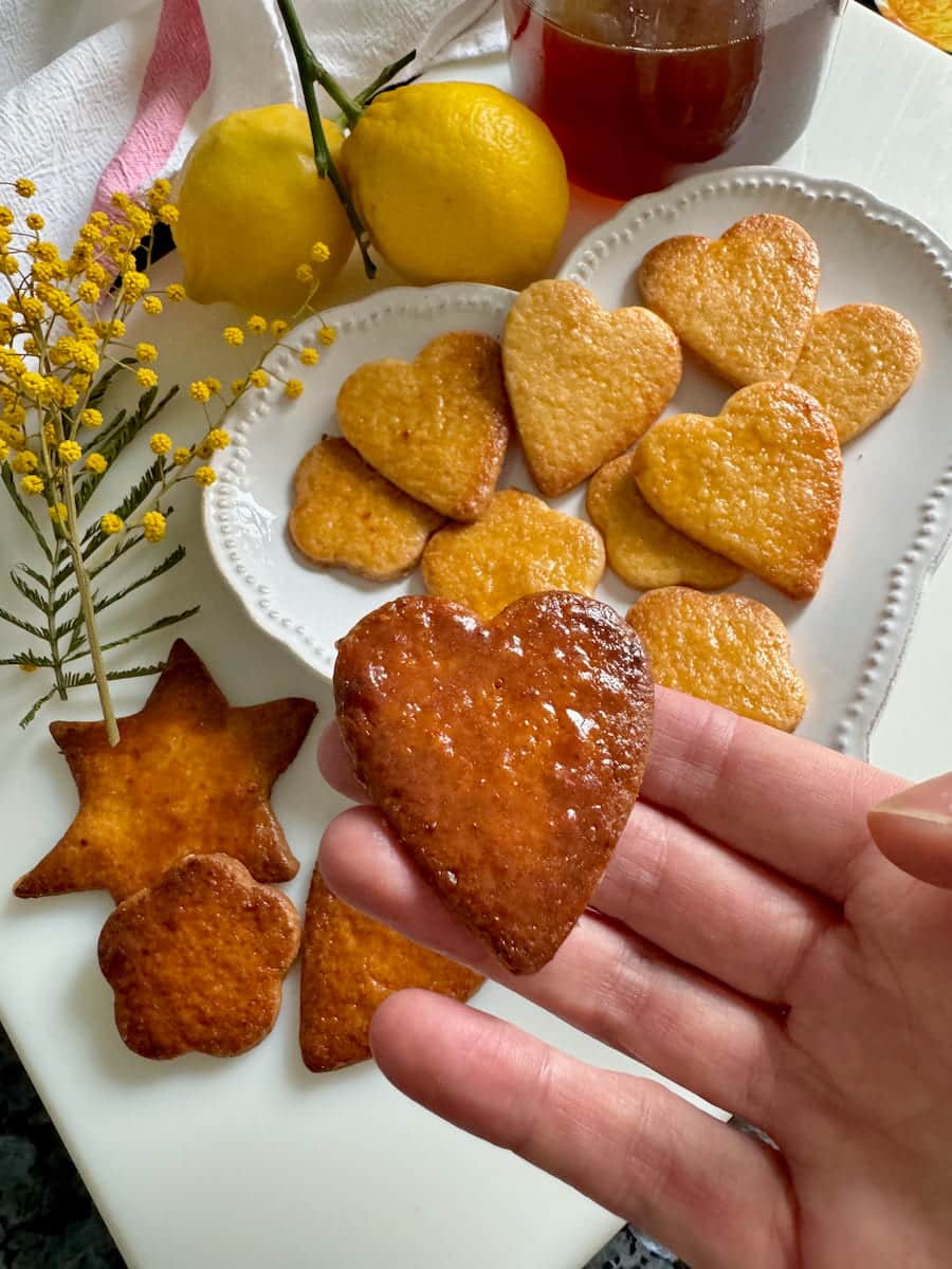 close-up of a well fired glazed honey cookie next to more golden - they are both good