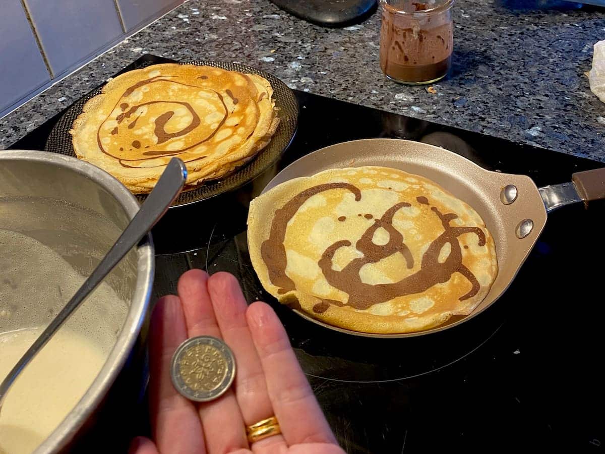holding a coin after flipping crepes