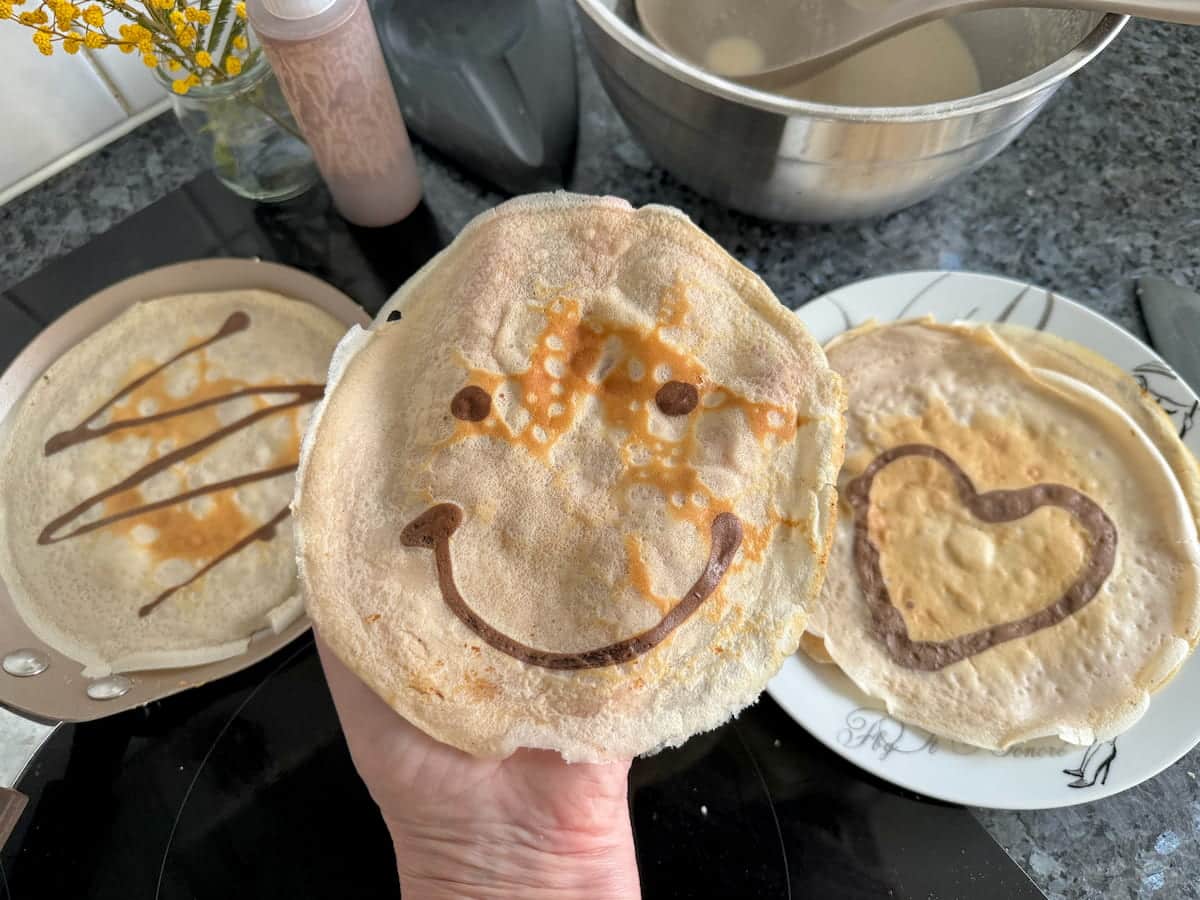 thin French crêpe pancakes with face, heart and zigzag designs with chocolate in the batter