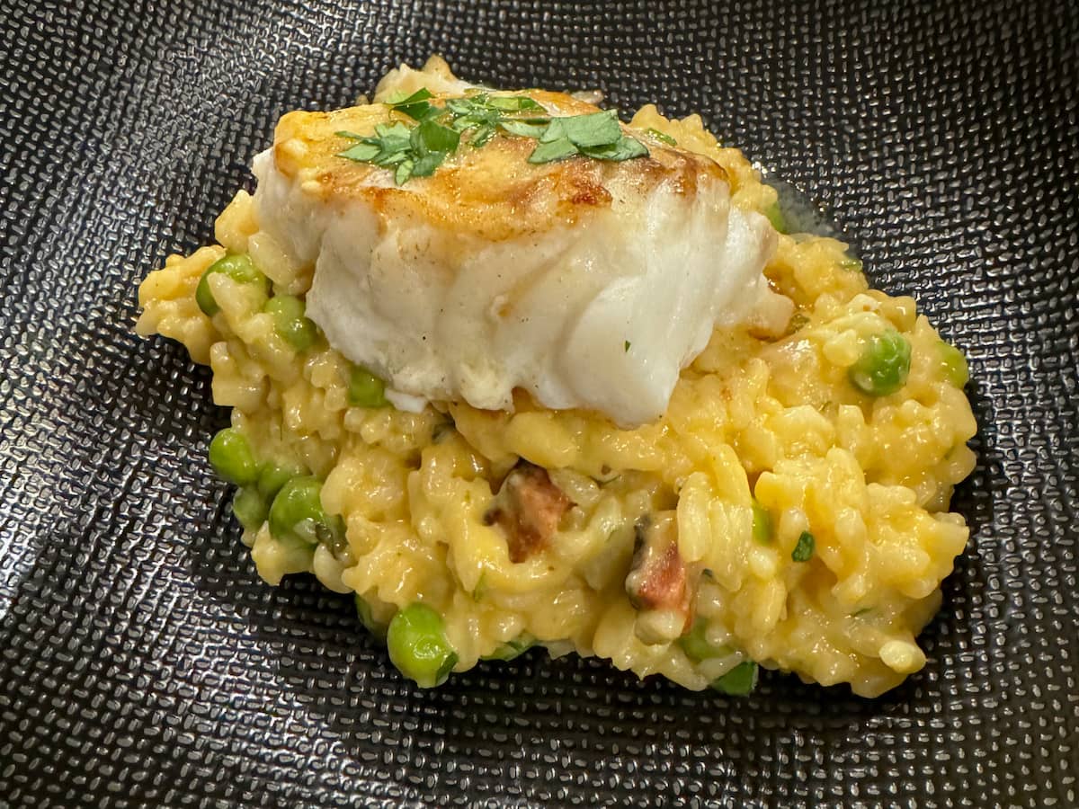 risotto with peas, topped with flaky white fish and parsely