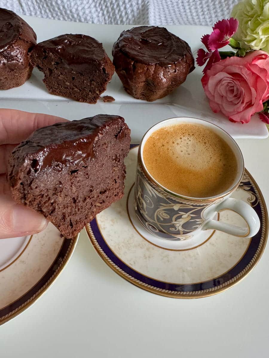 holding half of a chocolate coffee cake, seeing the moist inside topped with a coffee glaze