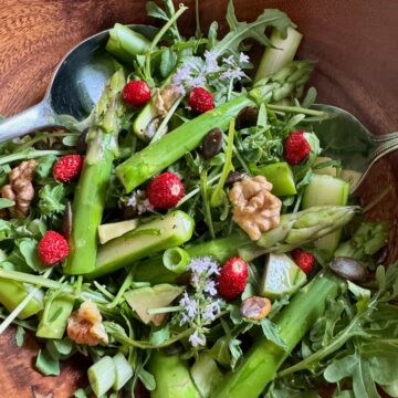 tossed green salad with seasonal fresh vegetables such as arugula, avocado and other greens with toasted nuts and seeds