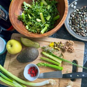 creating a simple green salad with fresh produce, nuts and seeds