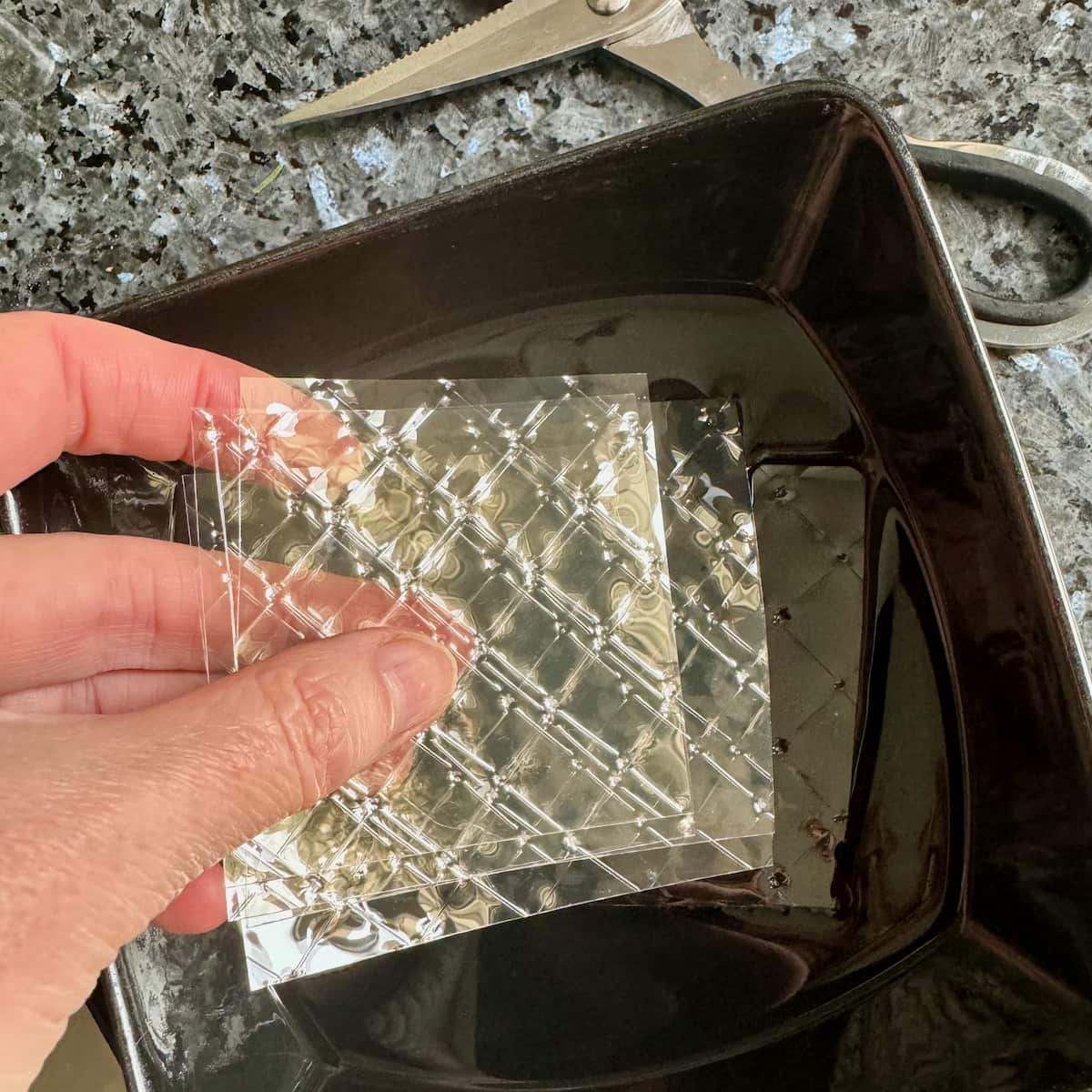placing gelatin sheets into a bowl of cold water