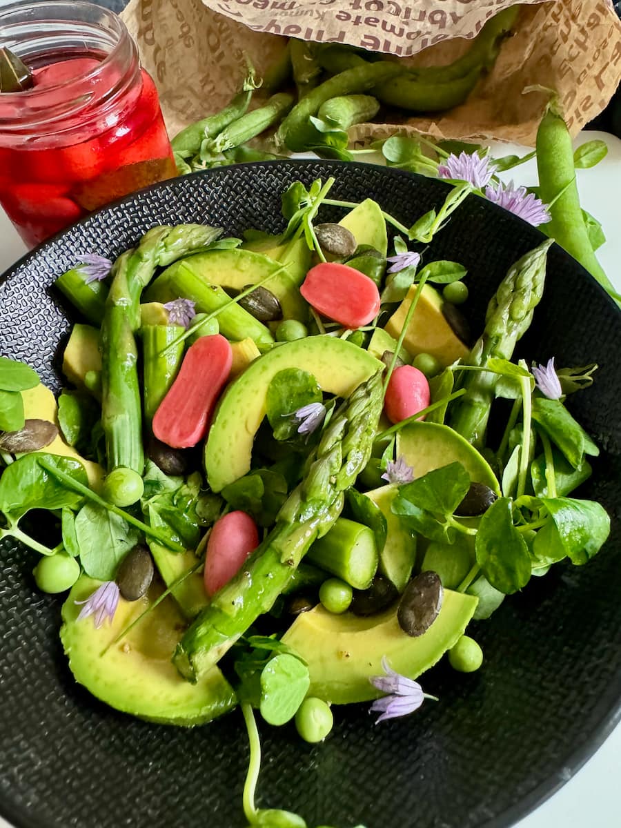 a colourful spring green salad: avocado, asparagus, peas, pea shoots, herbs, pumpkin seeds and pickled radish