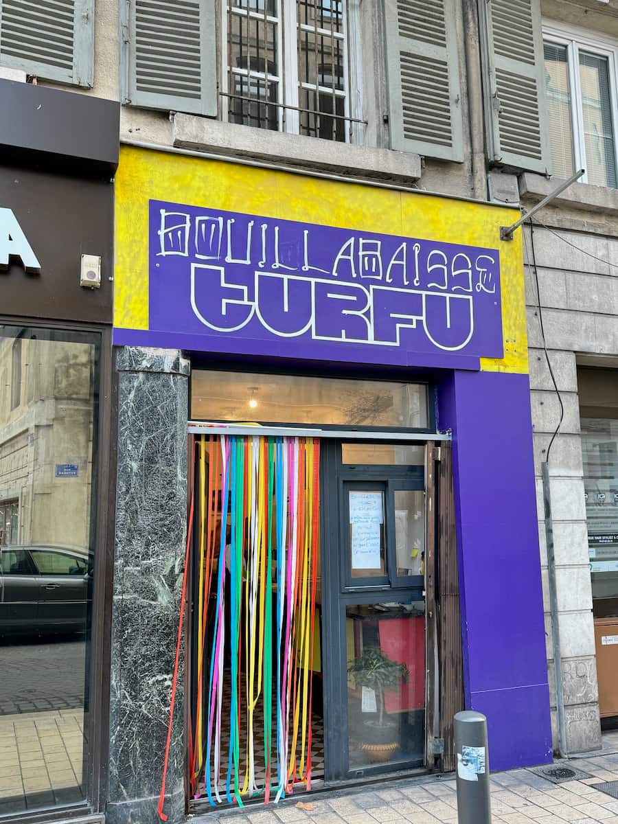 Bright shopfront with beaded curtain selling Bouillabaisse to go in Marseille