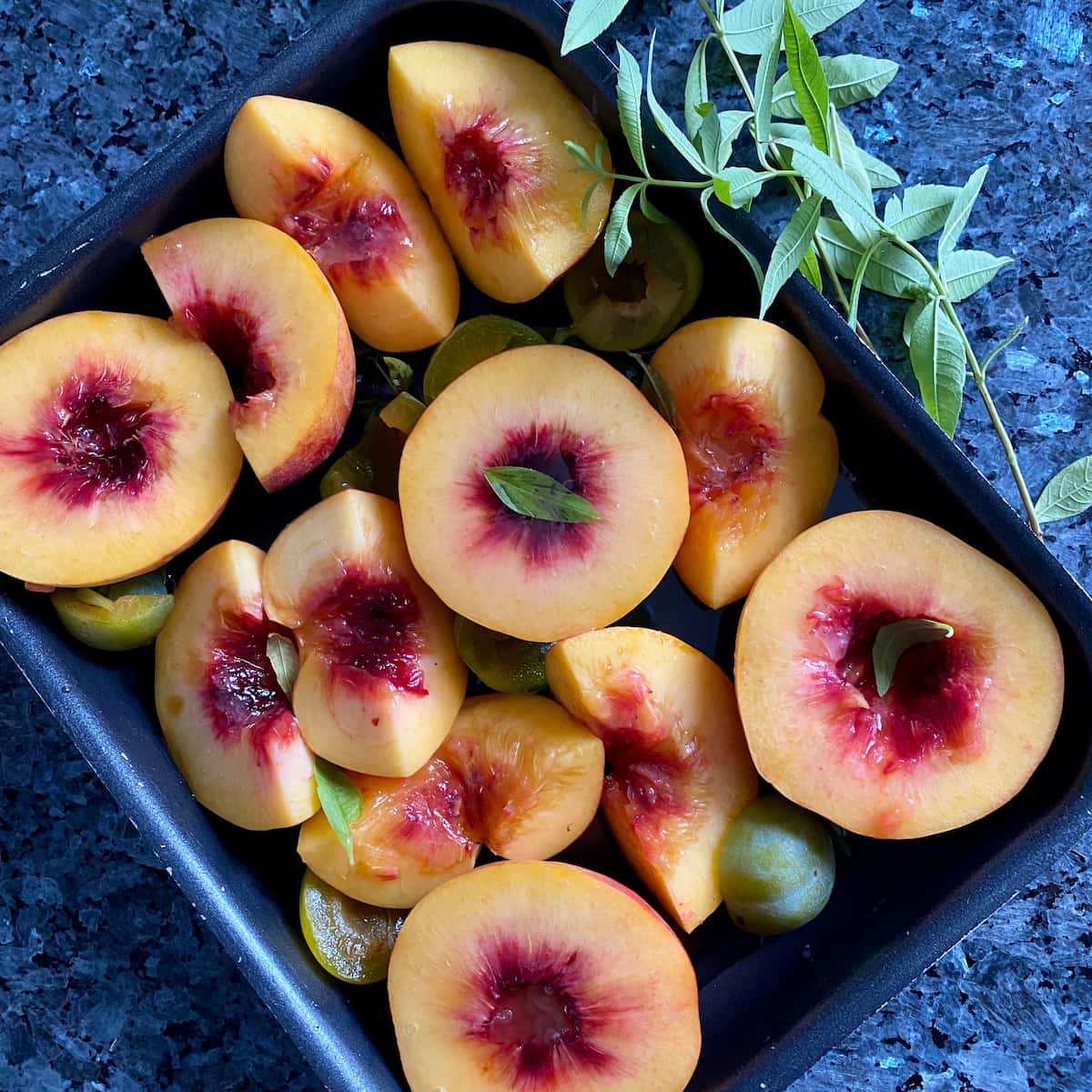 roasting tin of fresh peaches topped with honey and lemon verbena