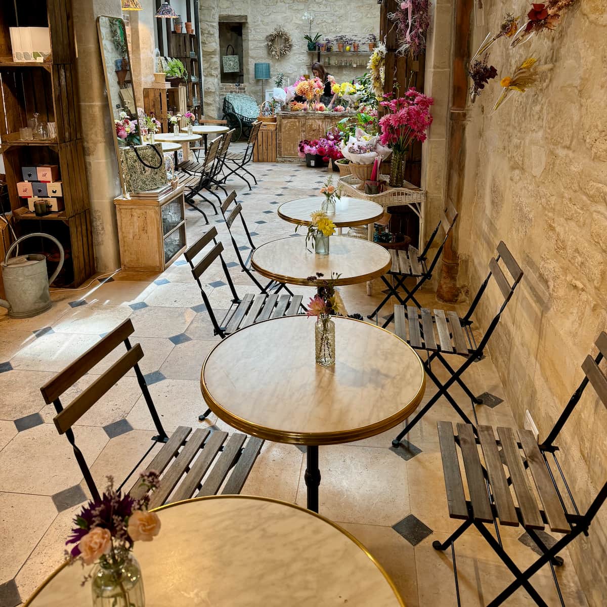 coffee tables amidst flowers in a tea room flower shop in rue du bac, Paris