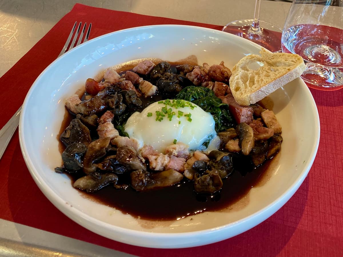 large bowl of poached egg and bacon in red wine