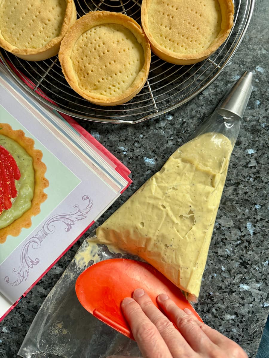 pushing out pastry cream in a piping bag using a scraper