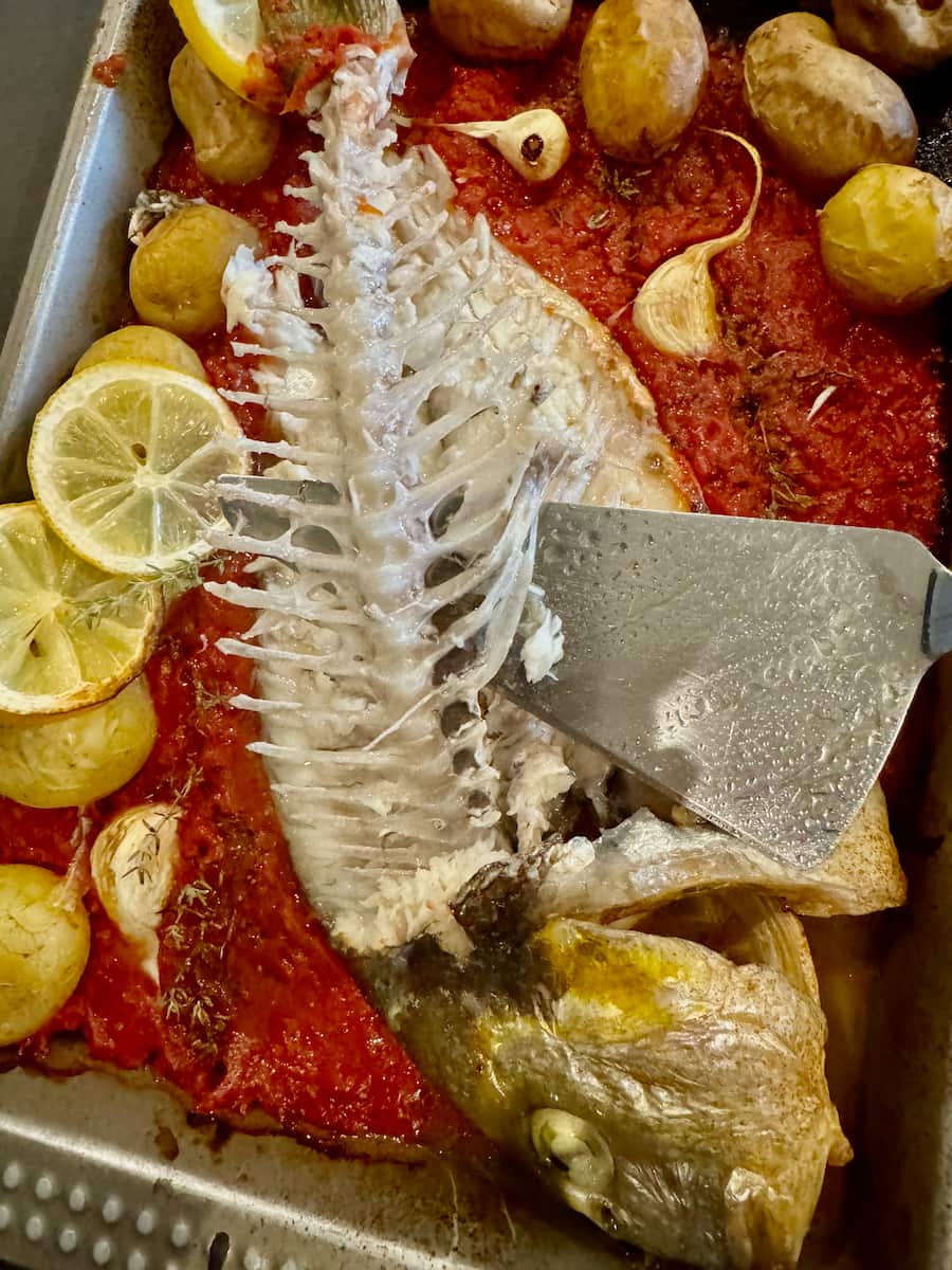 whole baked sea bream fish showing the inner bone, easy to remove