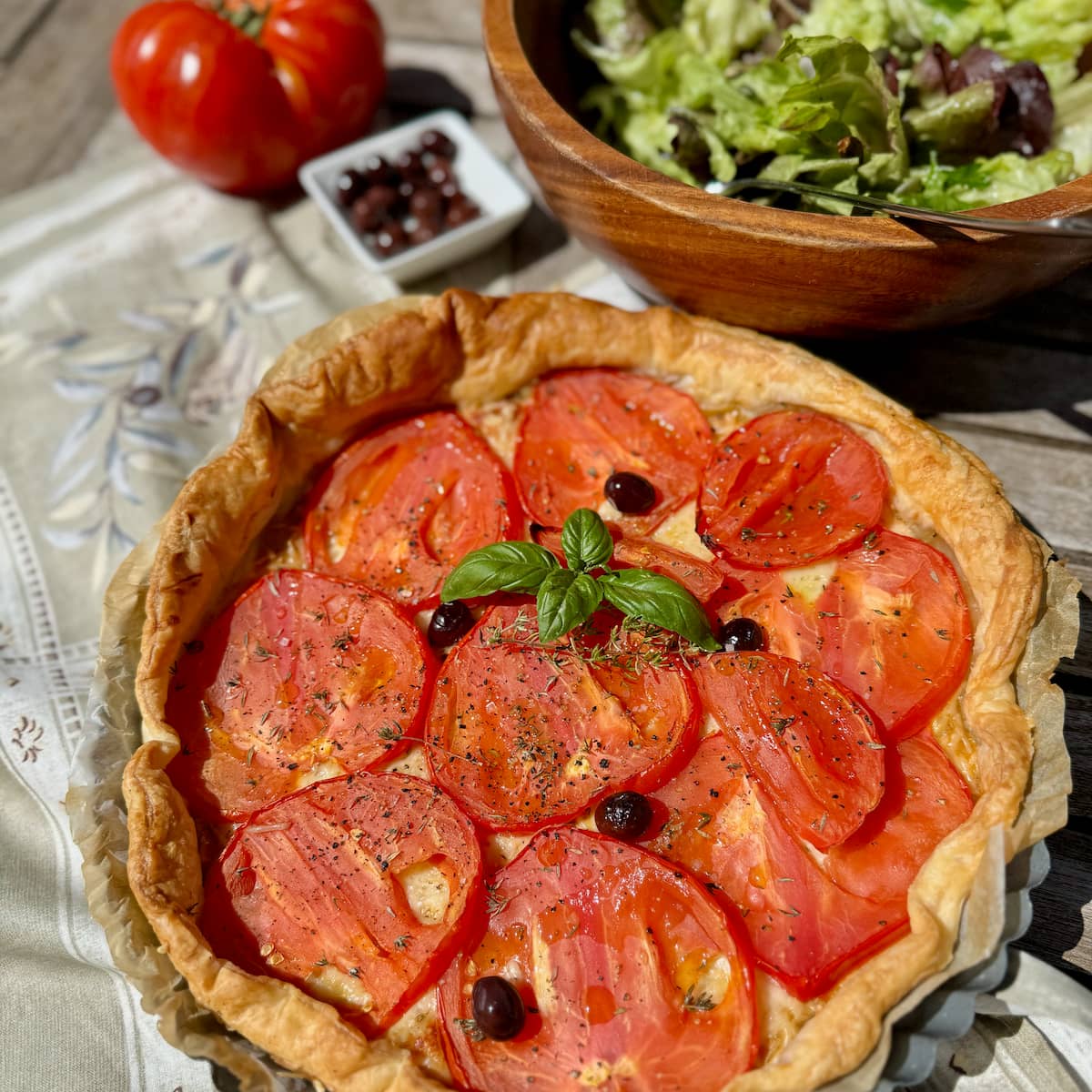 baked tomato tart with french niçoise olives, basil and a green salad