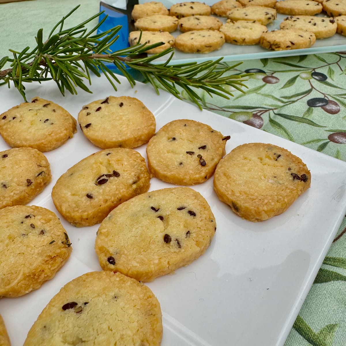 thin French sablé biscuits with cheese and seeds on plates for an aperitif