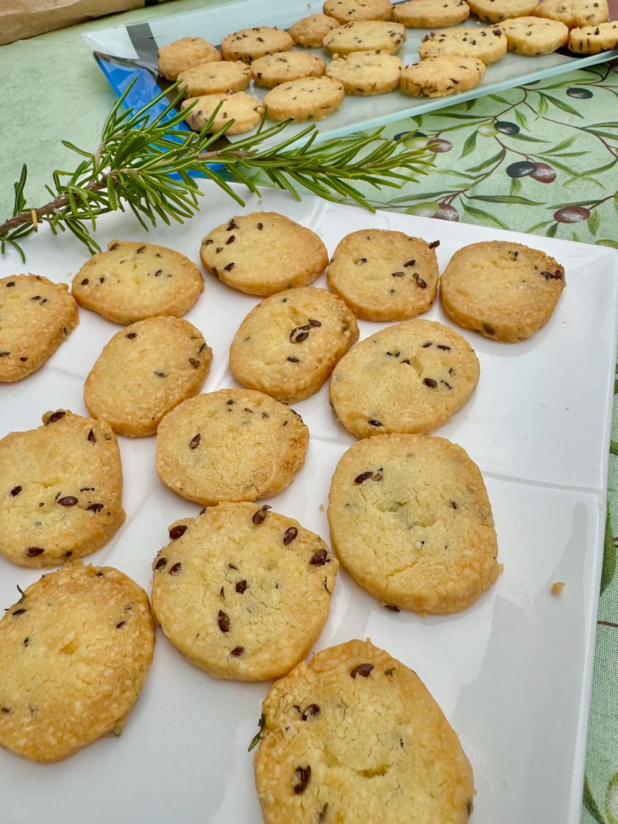 2 plates of golden crunchy mini cheese biscuits made with flax seeds and herbs