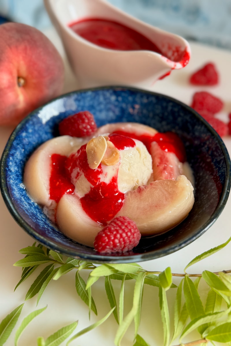 Peach Melba recipe of poached peaches, vanilla ice cream and raspberry puree